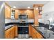 Modern kitchen with wooden cabinets, stainless steel appliances, and dark countertops at 445 Hamden Dr # 502, Clearwater Beach, FL 33767