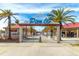 View of Pier 60 entrance with palm trees, shops, and playground on a sunny day with blue skies and a walkway at 445 Hamden Dr # 502, Clearwater Beach, FL 33767