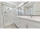 Bright bathroom features a double vanity, a glass-enclosed shower, and stylish tile flooring at 4717 W Mccoy St # 2, Tampa, FL 33616