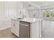 Sunlit kitchen island features stainless steel dishwasher and faucet; living area has multiple windows at 4717 W Mccoy St # 2, Tampa, FL 33616