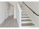 Modern staircase with sleek handrail, complemented by pristine white walls and light wood floors at 4717 W Mccoy St # 2, Tampa, FL 33616