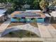 Aerial view of a blue house with a paved driveway and a well-manicured front yard at 4721 W Iowa Ave, Tampa, FL 33616