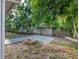A well-maintained backyard featuring a brick fire pit and beautiful mature landscaping surrounded by a wooden fence at 4721 W Iowa Ave, Tampa, FL 33616