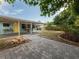 Beautifully designed backyard including a brick firepit, covered patio, mature landscaping, and outdoor lighting at 4721 W Iowa Ave, Tampa, FL 33616