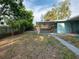 Spacious backyard including a covered patio, mature landscaping, and partial brickwork throughout at 4721 W Iowa Ave, Tampa, FL 33616