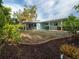 Expansive backyard, partially xeriscaped, featuring mature landscaping and a covered patio at 4721 W Iowa Ave, Tampa, FL 33616