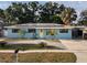 Inviting single-story home with solar panels, a paved driveway, and vibrant, well-maintained landscaping at 4721 W Iowa Ave, Tampa, FL 33616