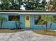 View of a front door with a wreath, surrounded by small palm trees at 4721 W Iowa Ave, Tampa, FL 33616