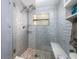 Beautiful walk-in shower boasts a unique mosaic floor, new fixtures, and glass door at 4721 W Iowa Ave, Tampa, FL 33616