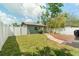 Backyard showcasing a well-maintained lawn, a wood deck, lush plants, and a white picket fence at 4767 6Th N Ave, St Petersburg, FL 33713