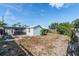 Spacious backyard features shed, patio area, and mature trees under a blue sky, offering outdoor potential at 5004 Suwannee Dr, New Port Richey, FL 34652
