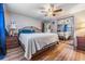 Inviting bedroom with a ceiling fan, wood-look flooring, and a large mirrored closet at 5004 Suwannee Dr, New Port Richey, FL 34652