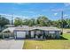 Charming single-story home with a well-manicured lawn and covered front porch seating area at 5004 Suwannee Dr, New Port Richey, FL 34652