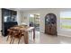 Well-lit dining area with a wooden table, cabinets, tile floors, and glass door leading to a screened lanai at 5208 Dandelion St, Apollo Beach, FL 33572