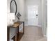 Bright entryway featuring a stylish console table, decorative mirror, and a welcoming white door at 5208 Dandelion St, Apollo Beach, FL 33572