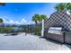 Outdoor grill area with a built-in grill, tile backsplash, a lake view, and a dining table at 5208 Dandelion St, Apollo Beach, FL 33572