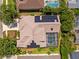 Aerial view of the home showing solar panels and screened pool, surrounded by lush landscaping at 5216 Kernwood Ct, Palm Harbor, FL 34685