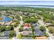 Beautiful aerial view of home nestled in a quiet neighborhood with a lake backdrop at 5216 Kernwood Ct, Palm Harbor, FL 34685