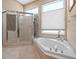 Bright bathroom showcasing a soaking tub adjacent to a glass door walk-in shower at 5216 Kernwood Ct, Palm Harbor, FL 34685