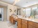 Bright bathroom featuring double vanity, a large mirror, and a walk-in closet entrance at 5216 Kernwood Ct, Palm Harbor, FL 34685