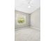 Simple bedroom with neutral carpet, walls, and natural light from window at 5216 Kernwood Ct, Palm Harbor, FL 34685