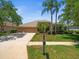 Beautiful home with a manicured lawn, mature trees, and a welcoming facade at 5216 Kernwood Ct, Palm Harbor, FL 34685