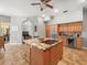 Well-equipped kitchen island with granite counters, stainless steel fridge, and access to living and dining areas at 5216 Kernwood Ct, Palm Harbor, FL 34685