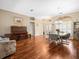 Open-concept living room featuring hardwood floors, neutral paint, and dining area with contemporary light fixture at 5216 Kernwood Ct, Palm Harbor, FL 34685