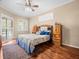 Comfortable main bedroom featuring hardwood floors, plantation shutters, and a ceiling fan at 5216 Kernwood Ct, Palm Harbor, FL 34685