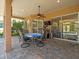 Covered patio features outdoor dining, tv, and relaxing view of screened in pool area and backyard at 5216 Kernwood Ct, Palm Harbor, FL 34685