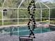 Screened pool area with a beautiful brick patio, serene water, and a glimpse of local wildlife resting in the background at 5216 Kernwood Ct, Palm Harbor, FL 34685