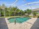Inviting pool and spa surrounded by a screened enclosure and brick pavers with lush landscaping at 5216 Kernwood Ct, Palm Harbor, FL 34685