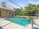Sparkling pool and spa with screened enclosure with a view of the house at 5216 Kernwood Ct, Palm Harbor, FL 34685