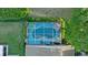 Aerial view of a private screened pool surrounded by lush landscaping, patio furniture, and shade umbrellas at 5520 Terrain De Golf Dr, Lutz, FL 33558