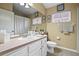 Neutral bathroom with a large mirror, white vanity, toilet, and a shower with a curtain at 5520 Terrain De Golf Dr, Lutz, FL 33558