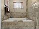 Well-decorated bathroom with a soaking tub and decorative tiles, perfect for unwinding after a long day at 5520 Terrain De Golf Dr, Lutz, FL 33558