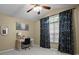Bedroom with a ceiling fan and natural light pouring through a large window with patterned curtains at 5520 Terrain De Golf Dr, Lutz, FL 33558