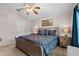 Warm bedroom featuring wooden bedframe, lamps and overhead ceiling fan at 5520 Terrain De Golf Dr, Lutz, FL 33558