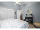 Cozy bedroom featuring light blue walls, a plush bed, and a decorative dresser with plants at 5520 Terrain De Golf Dr, Lutz, FL 33558