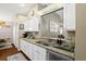 Kitchen area featuring granite counters, modern sink fixtures, and a view into the living space at 5520 Terrain De Golf Dr, Lutz, FL 33558