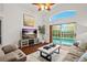 Comfortable living room with a large TV, cozy seating, and sliding glass doors opening to the outdoor pool area at 5520 Terrain De Golf Dr, Lutz, FL 33558