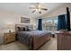 Well-lit main bedroom with a ceiling fan, plush carpet, and a sun-filled window with blue curtains at 5520 Terrain De Golf Dr, Lutz, FL 33558