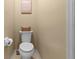 Standard toilet with a brown wicker basket on top of the tank, adding a decorative touch to the half bathroom at 5520 Terrain De Golf Dr, Lutz, FL 33558