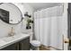 Modern bathroom featuring a shower-tub combination and black decorative accents at 616 Wheaton Trent Pl, Tampa, FL 33619