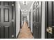 Long hallway with black doors, white trim, and herringbone wood floors at 616 Wheaton Trent Pl, Tampa, FL 33619