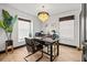 Well-lit home office featuring a chandelier, large windows, and modern desk at 616 Wheaton Trent Pl, Tampa, FL 33619