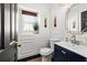 Stylish powder room featuring wainscoting, modern fixtures, and dark blue vanity with gold hardware at 616 Wheaton Trent Pl, Tampa, FL 33619