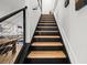 Modern staircase featuring wood treads, dark risers, and stainless steel cable railing at 616 Wheaton Trent Pl, Tampa, FL 33619