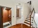 Hallway featuring an elevator, stairway with wooden steps, and an entrance to a carpeted room at 6404 Mayra Shores Ln, Apollo Beach, FL 33572