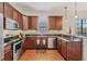 Modern kitchen with stainless steel appliances, granite countertops, and warm wood cabinetry for a stylish and functional space at 6404 Mayra Shores Ln, Apollo Beach, FL 33572